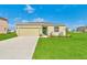 Charming single-story home featuring a well-maintained lawn, neutral exterior, and a two-car garage at 136 Columbia Dr, Kissimmee, FL 34759