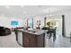 Modern kitchen with stainless steel appliances, dark cabinets, and an open floor plan to dining area at 136 Columbia Dr, Kissimmee, FL 34759