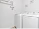 Modern laundry room with a sleek washer and dryer, decorated with laundry-themed wall art at 136 Columbia Dr, Kissimmee, FL 34759