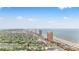 Stunning aerial view of a coastal community with beach access and high-rise oceanfront condos under a blue sky at 1420 N Grandview Ave, Daytona Beach, FL 32118