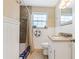 Cozy bathroom featuring tile floors, white wainscoting and a shower and tub at 1420 N Grandview Ave, Daytona Beach, FL 32118