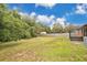 Large backyard featuring mature trees, a privacy fence, a shed, and a charming fire pit perfect for entertaining at 1431 1St Ave, Deland, FL 32724
