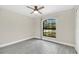 Sunny bedroom showcasing wood-look tile flooring, base trim, ceiling fan and large window at 1431 1St Ave, Deland, FL 32724