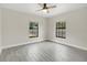 Neutral bedroom featuring wood-look tile flooring, base trim, ceiling fan and dual windows at 1431 1St Ave, Deland, FL 32724