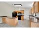 Well-lit kitchen with sleek black appliances, wood cabinets, breakfast bar, and stylish gray tile flooring at 1431 1St Ave, Deland, FL 32724