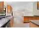 Bright kitchen featuring wood cabinets, dark countertops, stainless steel sink, and wood-look tile flooring at 1431 1St Ave, Deland, FL 32724