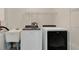 Well-equipped laundry room featuring a modern washer and dryer with overhead shelving and a utility sink at 1431 1St Ave, Deland, FL 32724