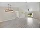 Open living room filled with neutral paint, tile flooring, modern light fixture, and large window at 1431 1St Ave, Deland, FL 32724