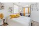 Bright bedroom featuring white walls, wood floors, and a cozy bed with yellow decorative pillows at 1455 Whitewood Dr, Deltona, FL 32725