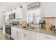 Eat-in kitchen with granite countertops, a stainless steel sink, and white cabinets providing an efficient workspace at 1455 Whitewood Dr, Deltona, FL 32725