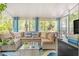 Inviting sunroom featuring comfortable wicker furniture, bright curtains, and tranquil outdoor views at 1455 Whitewood Dr, Deltona, FL 32725