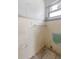 Bathroom corner with tiled walls and a window; ready for a complete makeover at 1612 W Grant St, Orlando, FL 32805