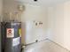 Bare laundry room with hot water heater and connection points awaiting a washer and dryer at 1612 W Grant St, Orlando, FL 32805