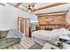 Comfortable bedroom with brick fireplace, beamed ceiling, and beach view at 1660 E Apache Cir, Deltona, FL 32725