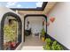 Inviting front porch featuring brick arches, potted plants, and decorative wall hangings at 1660 E Apache Cir, Deltona, FL 32725