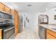 Well-lit kitchen featuring stainless steel appliances, wooden cabinetry, and a view into the living room at 1660 E Apache Cir, Deltona, FL 32725
