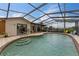 Enclosed pool featuring a screened enclosure, tile deck, and stairs leading into the clear blue water at 1660 E Apache Cir, Deltona, FL 32725