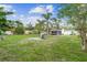 Spacious backyard with palm trees, a covered seating area, and an in-ground sprinkler system at 1702 Palmetto Ave, Deland, FL 32724