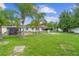 Expansive backyard view with seating area, featuring lush grass and mature trees at 1702 Palmetto Ave, Deland, FL 32724