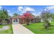 Charming brick home featuring a well-maintained lawn and blooming pink flowers in the front yard at 1702 Palmetto Ave, Deland, FL 32724