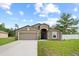 Lovely single-story home featuring a two-car garage, green lawn, and a partially fenced yard at 1846 N Acadian Dr, Deltona, FL 32725