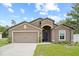 Inviting single-story home with a well-maintained lawn, two-car garage, and a welcoming arched entryway at 1846 N Acadian Dr, Deltona, FL 32725