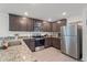 Modern kitchen featuring stainless steel appliances, granite countertops, and dark brown cabinetry at 1846 N Acadian Dr, Deltona, FL 32725