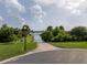 Scenic boat ramp leading to a tranquil lake, surrounded by lush greenery and a bright blue sky with fluffy clouds at 19232 Park Place Blvd, Eustis, FL 32736