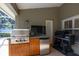 Covered outdoor kitchen with stainless steel grill and refrigerator at 19232 Park Place Blvd, Eustis, FL 32736