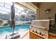 Outdoor kitchen next to a large in-ground pool at 19232 Park Place Blvd, Eustis, FL 32736