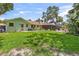 Spacious backyard with a manicured lawn, connecting to a screened patio, perfect for outdoor living at 204 Rio Pinar Dr, Ormond Beach, FL 32174