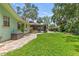Lush green backyard with a stone path leading to a screened patio and outdoor living area at 204 Rio Pinar Dr, Ormond Beach, FL 32174