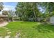 Green backyard with a stone pathway leading to a screened patio, surrounded by lush landscaping at 204 Rio Pinar Dr, Ormond Beach, FL 32174