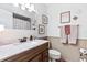 Well-lit bathroom with a marble vanity, wall decor, decorative mirror, and a full toilet at 204 Rio Pinar Dr, Ormond Beach, FL 32174