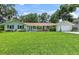 Charming single-story home with a lush green lawn and colorful exterior paint at 204 Rio Pinar Dr, Ormond Beach, FL 32174