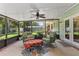 Relaxing screened patio featuring comfortable chairs, stylish rug, and ceiling fan at 204 Rio Pinar Dr, Ormond Beach, FL 32174