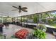 Inviting screened porch with outdoor seating, ceiling fan, string lights, and peaceful backyard views at 204 Rio Pinar Dr, Ormond Beach, FL 32174