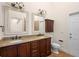 Bathroom with double sinks, granite counters, wood cabinets and tile floors at 2263 Catbriar Way, Oviedo, FL 32765