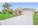 Lovely home showcasing a manicured lawn, palm trees, and a long driveway to the two-car garage at 2263 Catbriar Way, Oviedo, FL 32765