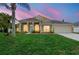 Beautiful home with large windows, columns, and a well-maintained lawn under a colorful sunset sky at 2263 Catbriar Way, Oviedo, FL 32765