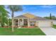 Well-maintained single-Gathering home featuring a manicured lawn, palm trees, and a two-car garage at 2263 Catbriar Way, Oviedo, FL 32765