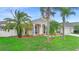 Attractive home with mature palm trees, a green lawn, and a driveway leading to a two-car garage at 2263 Catbriar Way, Oviedo, FL 32765