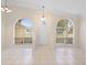 Open living room features tile flooring and high ceilings with arch windows at 2263 Catbriar Way, Oviedo, FL 32765