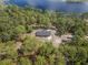 Aerial view of a sprawling estate, surrounded by lush green trees and bordering a tranquil lake at 2620 Doyle Rd, Deltona, FL 32738