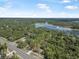 Beautiful aerial view of property with surrounding nature, showcasing proximity to both road access and a serene, picturesque lake at 2620 Doyle Rd, Deltona, FL 32738