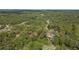 Expansive aerial view of land, showcasing the property's wooded setting and secluded location with a home nestled among trees at 2620 Doyle Rd, Deltona, FL 32738