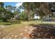 Expansive backyard with mature trees and a tennis court, ideal for recreation and outdoor enjoyment at 2620 Doyle Rd, Deltona, FL 32738