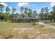 Exterior shot of charming single-story home and gated backyard with manicured lawn at 2620 Doyle Rd, Deltona, FL 32738
