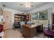 Inviting home office space featuring a ceiling fan, desk, shelving, and large windows overlooking the yard at 2620 Doyle Rd, Deltona, FL 32738