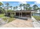 A screened-in porch with furniture overlooking a fenced backyard and a glimpse of the lake at 2620 Doyle Rd, Deltona, FL 32738